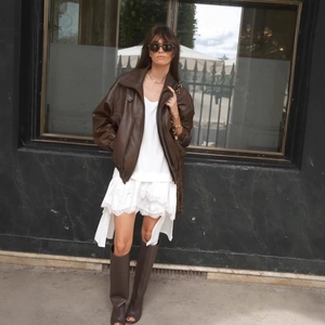 Tenue chic avec veste en cuir marron et robe en dentelle blanche à ourlet irrégulier