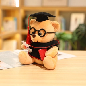 Detail of graduation teddy bear with black glasses and diploma on a wooden desk