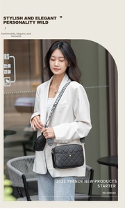 Detail of black quilted crossbody bag with a printed wide strap and mini round pouch