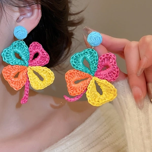 Colorful raffia woven flower earrings with clover petals and bohemian summer holiday design