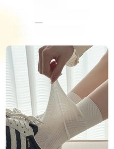 Detailed view of white hollow vertical stripe crew socks with high elasticity and breathability