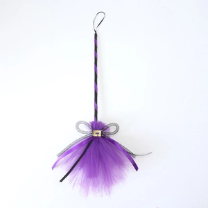 Close-up of Halloween witch broom with purple mesh, black ribbon and gold buckle detail