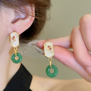 Detail showing gold-edged white enamel top and green jade-style pendant earrings