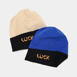 Detailed view of knitted beanie hats with color blocking and orange LUCK letter embroidery