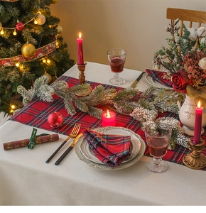Festive red plaid table runner set with candles and pine berry wreath decoration