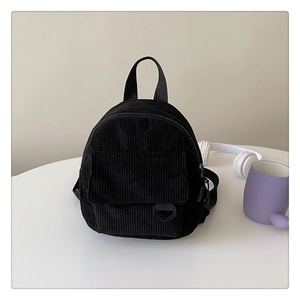Detail view of black corduroy mini backpack with front pocket and adjustable straps