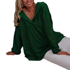 Detail eines dunkelgrünen Oversized-Hoodies mit glitzernden Pailletten und V-Ausschnitt