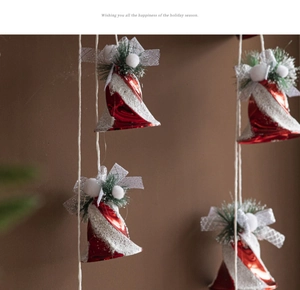 Close-up of red Christmas bells with snow flocking and silver mesh ribbon bows