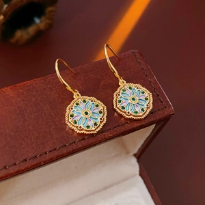 Detail of vintage flower earrings with green gemstone and colorful enamel in a gift box