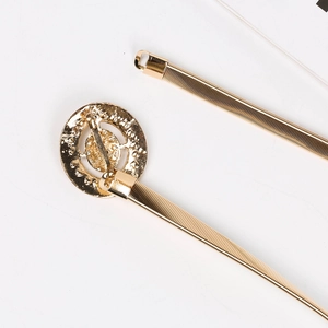 Détail de la ceinture à ressort dorée avec boucle ronde en strass sur fond blanc