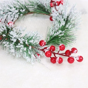 Macro view of cedar pine needles with white flocking and red berries for Christmas decor