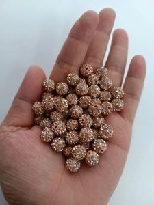 Macro detail of 10mm champagne gold pave disco ball clay beads for jewelry making