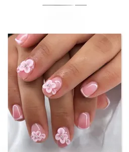 Detail of pink gradient press-on nails with 3D white flowers and French tips