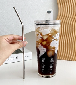 Macro detail of 1L glass straw cup showing world map print and iced coffee texture
