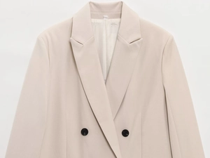 Gros plan du revers d'un blazer beige à double boutonnage et texture de tissu