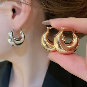 Chic gold and silver polished metal C-shaped hoop earrings for women in a minimalist style