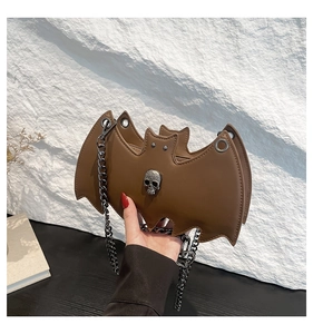 Macro shot of brown bat-shaped bag featuring vintage skull hardware and matte leather