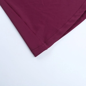 Détail de la couture à double aiguille sur l'ourlet d'une robe bordeaux à fente