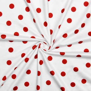 Detailed close-up of white fabric with red polka dots in a creative spiral fold pattern
