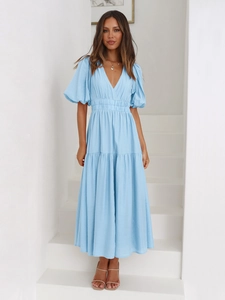Detailed view of sky blue V-neck dress with puff sleeves and textured fabric