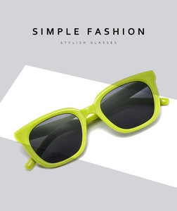 Detail view of fluorescent green square sunglasses with dark lenses on a minimalist background