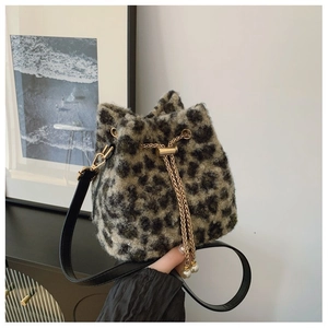 Detailed view of plush leopard print bucket bag with gold chain and pearl accent