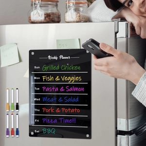 Detail of black magnetic acrylic weekly planner on fridge with six colorful markers