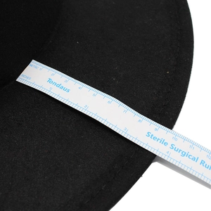 Medición detallada del ala ancha de un sombrero de fieltro negro con regla flexible