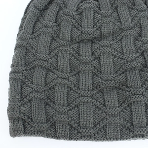 Detailed macro view of dark grey basketweave knit pattern on a warm winter beanie