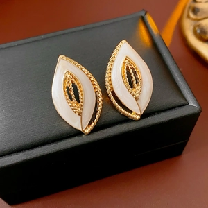 Detailaufnahme von Vintage-Blatt-Ohrringen mit weißer Emaille auf einer Schmuckschatulle