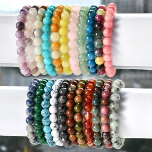 Variety of 8mm natural stone beaded bracelets for men and women on a white display stand