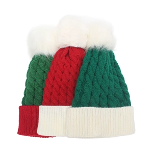 Knitted Christmas beanie hats with fluffy pom-poms in festive red, green and white colors
