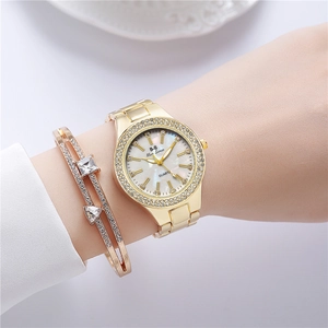 Détail d'une montre dorée avec cadran marbré et bracelet en diamant assorti au poignet