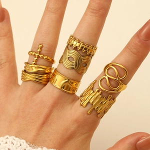 Close-up of gold irregular lava rings and hollow geometric bands on model fingers
