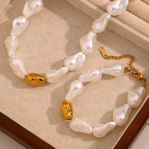 Parure de bijoux avec collier et bracelet en perles baroques et acier doré 18 carats