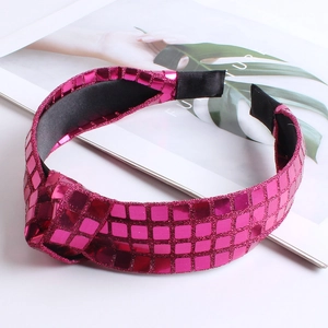 Detail of rose red knotted headband with sequin checkered pattern on a magazine