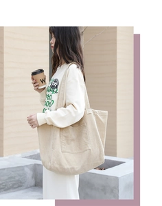 Detailed texture of beige corduroy tote bag with large front pocket and soft finish