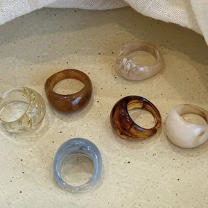Vintage oval resin rings in amber, tortoiseshell, and cream finishes on a tray