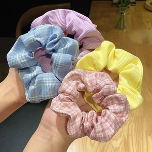 Close-up of four colorful floral scrunchies in blue, pink, yellow and purple fabrics
