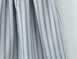 Detailed macro view showing blue vertical stripes on light gray cotton linen fabric texture