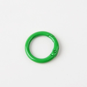 Macro detail of a bright green 23mm metal spring O-ring with glossy finish
