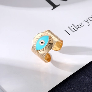 Detail of gold evil eye ring featuring blue enamel and hammered metal texture
