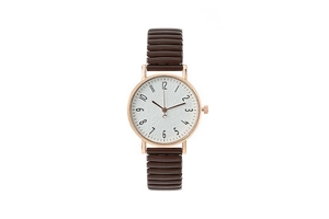 Detail of rose gold case and brown elastic metal band on white textured dial watch