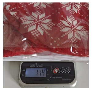 Close-up of a red knitted Christmas gift bag with snowflake patterns weighing 114g