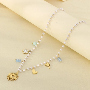 Detail of bohemian pearl necklace with gold heart pendants and colorful beads
