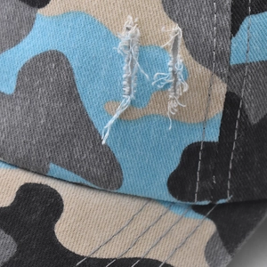 Gros plan sur une casquette camouflage en coton pour queue de cheval avec détails déchirés