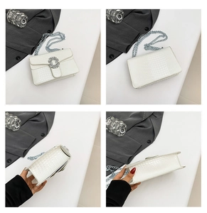 Detail view of white crocodile pattern bag with rhinestone buckle and chain strap