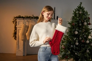 Close-up of a red knitted Christmas stocking with heart pattern and soft tassels