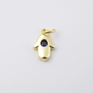 Golden Hamsa Hand pendant with a central deep blue zircon gemstone on white background