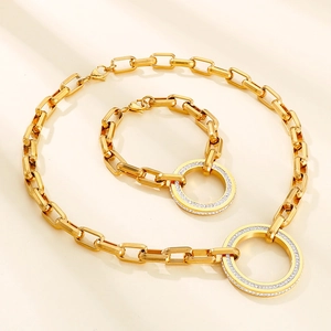 Detailed shot of gold chunky curb chain necklace and bracelet with crystal-set round charms
